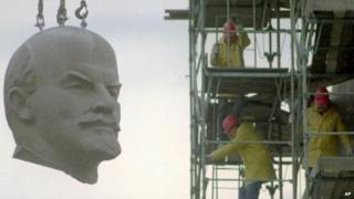The huge granite head of Berlins Lenin statue is hanging at a crane during its dismantling in Berlin November 13, 1991.