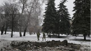 Ukrainian servicemen pass the crater of a shell in the city centre of Debaltseve, 22 January 2015