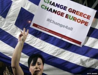 Syriza supporter holds flag and placard (22 Jan)