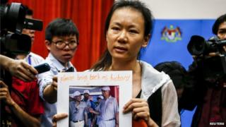 The wife of a passenger aboard the missing Malaysia Airlines Flight MH370, holds a picture of her husband, at a news conference in Putrajaya, 29 January 2015