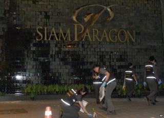 Thai police forensic officers investigate near the front of the Siam Paragon shopping mall, the site of a blast in Bangkok, Thailand, Sunday, Feb. 1, 2015.