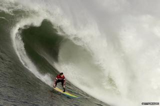 Colin Dwyer rides a wave during the Mavericks Invitational on January 24, 2014 in Half Moon Bay, California.