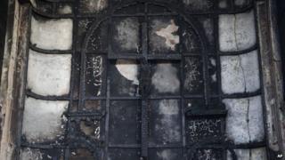 A burnt crucifix stands at the altar of St Sebastian's Church after a fire destroyed the church on Monday, in New Delhi, India, Tuesday, Dec. 2, 2014.