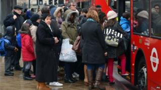 Commuters queue to get onto a bus outside Vauxhall bus station