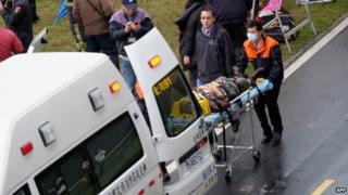 Rescue personnel put an injured passenger from a TransAsia flight that crash-landed into a river outside Taiwan's capital Taipei into an ambulance