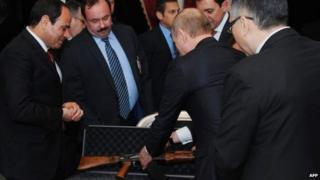 Russian President Vladimir Putin (second right) presents Egyptian President Abdul Fattah al-Sisi with a Kalashnikov AK-47 rifle before talks in Cairo (10 February 2015)