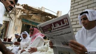 Кувейтский мужчина читает местную газету среди друзей