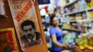 President Nicolas Maduro and the word "devaluated" is seen at a market in Caracas February 13, 2015.