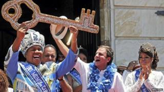 Rio de Janeiro"s Mayor Eduardo Paes (2nd R) hands over the city"s ceremonial key to the Rei Momo, or Carnival King Wilson Neto (L) at Cidade Palace in Rio de Janeiro