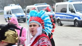 Would-be revellers stand in front of police cars in Braunschweig, Germany, on Sunday after police in the northern German city cancelled the annual carnival procession shortly before it was due to begin over fears of a terrorist attack