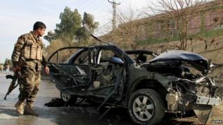 A member of the Afghan security forces inspects the site of a bomb blast targeting the vehicle of Angeza Shinwari, member of the Provincial Council of Nangarhar province, in Jalalabad, Afghanistan, 10 February 2015.