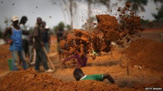 A grave digger works at a US-built cemetery on 27 January 2015 in Disco Hill, Liberia