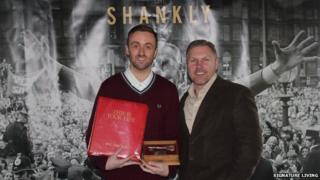 Bill Shankly's grandson Chris Carline holding memorabilia