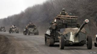Members of the Ukrainian armed forces ride armoured personnel carriers as they pull back from Debaltseve region, near Artemivsk