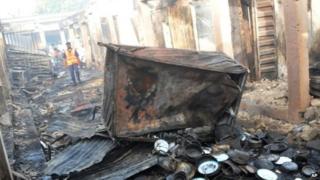 People inspect damaged shops following a bomb explosion at a Market in Bauchi, Nigeria (December 2014)
