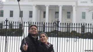 Couple take photo with selfie stick in front of the White House