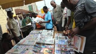 Люди читают заголовки газет в Нигерии - 2011