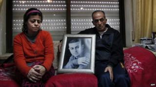 The parents of Arab-Israeli Muhammad Said Ismail Musallam sit next to a framed portrait of their son. Photo: February 2015