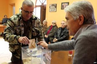 A man casts his ballot during the first round of the French departmental elections on 22 March 2015 in Corsica