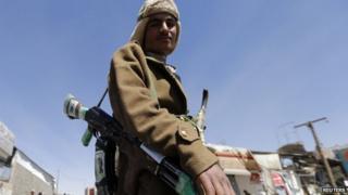 A Houthi fighter poses for a photo outside a presidential guards barrack on a mountain overlooking the presidential palace in Sanaa January 20, 2015