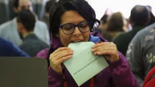A woman prepares to cast her vote for the Andalusian regional elections at a polling station in the Andalusian capital of Seville