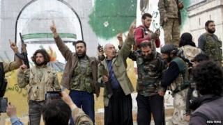 Rebel fighters celebrate at the Mihrab roundabout in the Idlib city centre, after they took control of the area, 28 March 2015.