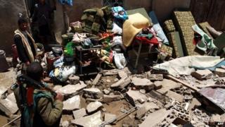 Yemenis inspect the aftermath of an air strike near Sanaa's airport (31 March 2015)