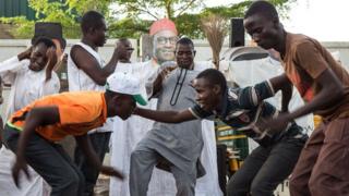 Nigerians in Kaduna dance in front of a picture of Muhammadu Buhari during the election voting days