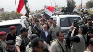 Премьер-министр Ирака Хайдер аль-Абади развевает иракский флаг в Тикрите (1 апреля 2015 года)