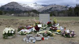 Flowers are pictured in front of a stella commemorating the victims