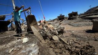 A man removes mud from his house after torrential rains and floods in Diego de Almagro, Chile, 28 March 2015.