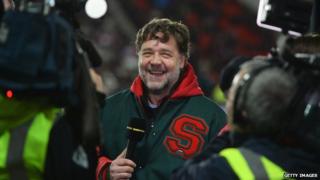 Actor and co-owner of South Sydney Rabbitohs Russell Crowe is interviewed by the BBC prior to the World Club Challenge match between St Helens and South Sydney Rabbitohs at Langtree Park on 22 February 2015 in St Helens, England.