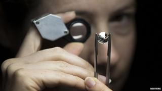 A jeweller scrutinises a diamond