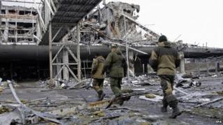 Pro-Russian separatists walk near the destroyed Donetsk International Airport, in Donetsk, Ukraine, 04 April 2015