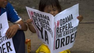 A child reads a sign in favour of the US repealing sanctions against Venezuela in Panama City on 10 April 2015.