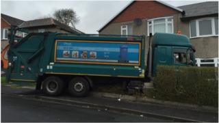 Bin lorry in front garden of house in Glasgow