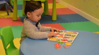 Carlson Chuen, aged two, plays with a puzzle during a session at the HKYTA, 25 February 2015