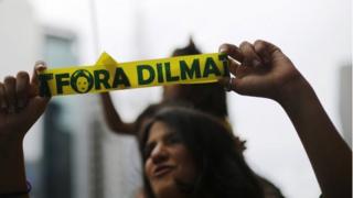 Демонстрант держит ленту с надписью «Out Dilma» во время акции протеста против президента Бразилии Дилмы Руссефф в Сан-Паулу