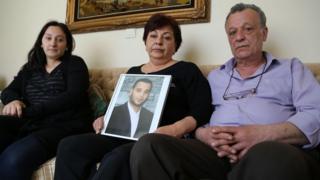 Sevag Balikci's family hold a photo of him