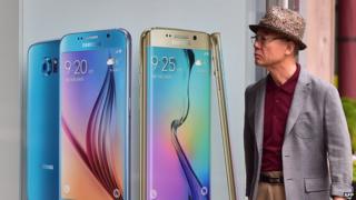 A man walks past a billboard showing the Samsung Galaxy S6 and S6 edge at a store in Seoul