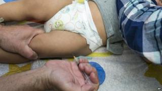 In this Jan. 29, 2015 file photo, a pediatrician uses a syringe to vaccinate a 1-year-old with the measles-mumps-rubella (MMR) vaccine in Northridge, Calif