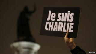 A man holds a placard which reads "I am Charlie" to pay tribute during a gathering at the Place de la Republique in Paris 7 January 2015