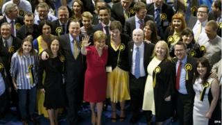 Лидер Шотландской национальной партии (SNP) Никола Осетрин (C-L) празднует семь новых членов парламента от Глазго