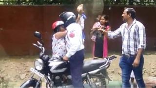 policeman throwing brick at woman