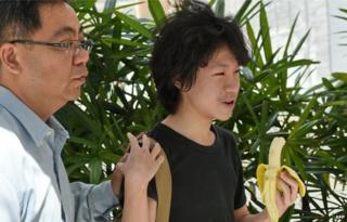 16-year-old student Amos Yee walks with his father to the State courts in Singapore on 17 April 2015.