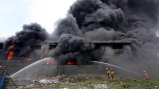 Firemen train their hoses at the burning Kentex footwear factory at Valenzuela city, a northern suburb in Manila, Philippines, Wednesday, May 13, 2015