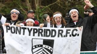 Fydd y cefnogwyr yma ddim yn gwenu ar ôl clywed am gynlluniau diweddara Undeb Rygbi Cymru