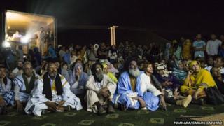 Люди смотрят фильм в лагере Дахла в Алжире