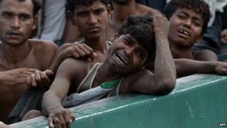 Мигрант рохинджа плачет, когда он сидит с другими в лодке, плывущей в тайских водах у южного острова Ко Липе в Андаманском море, 14 мая 2015 года