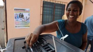 Женщина голосует на выборах в Гане в 2012 году